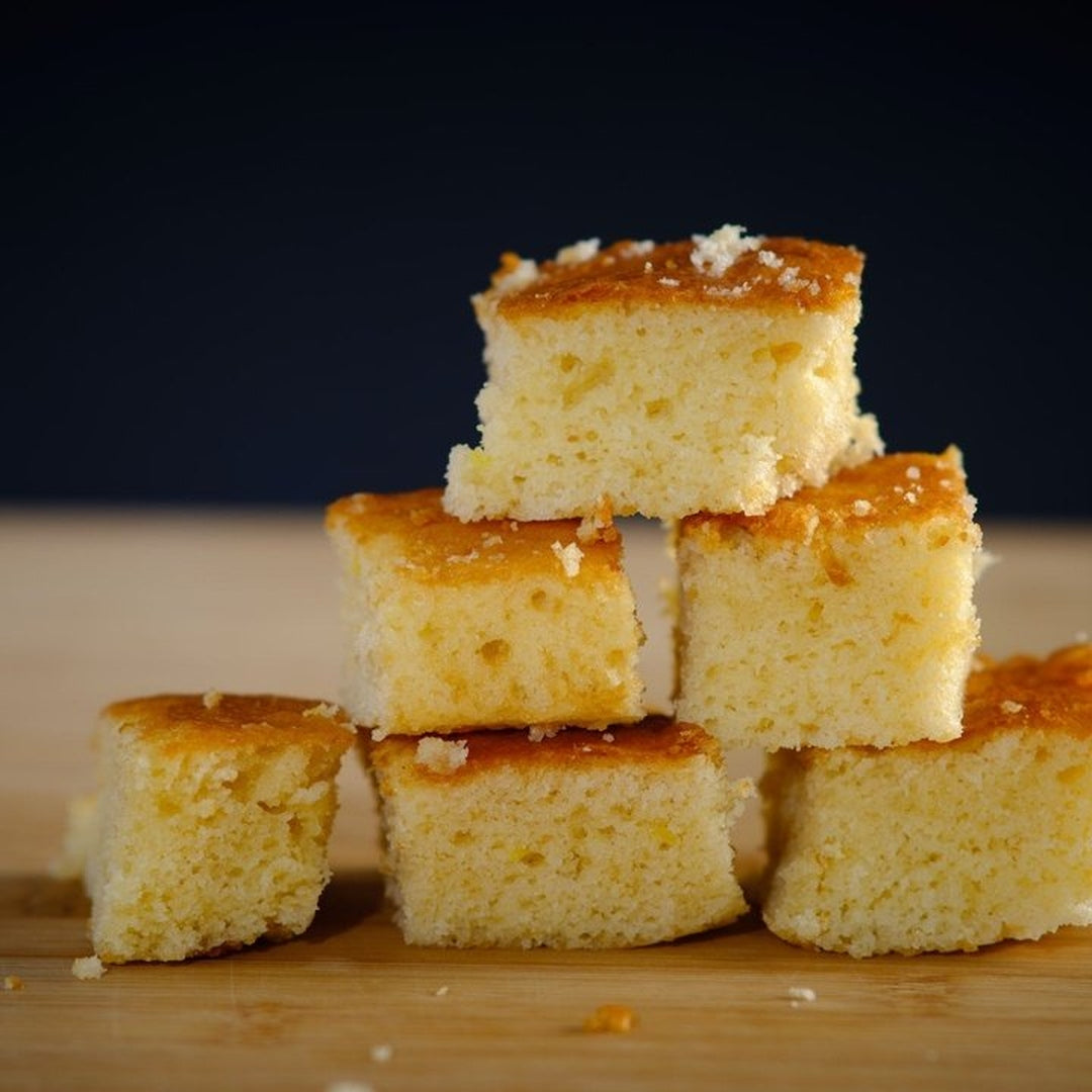Stack of honey glazed cornbread squares on a wooden board