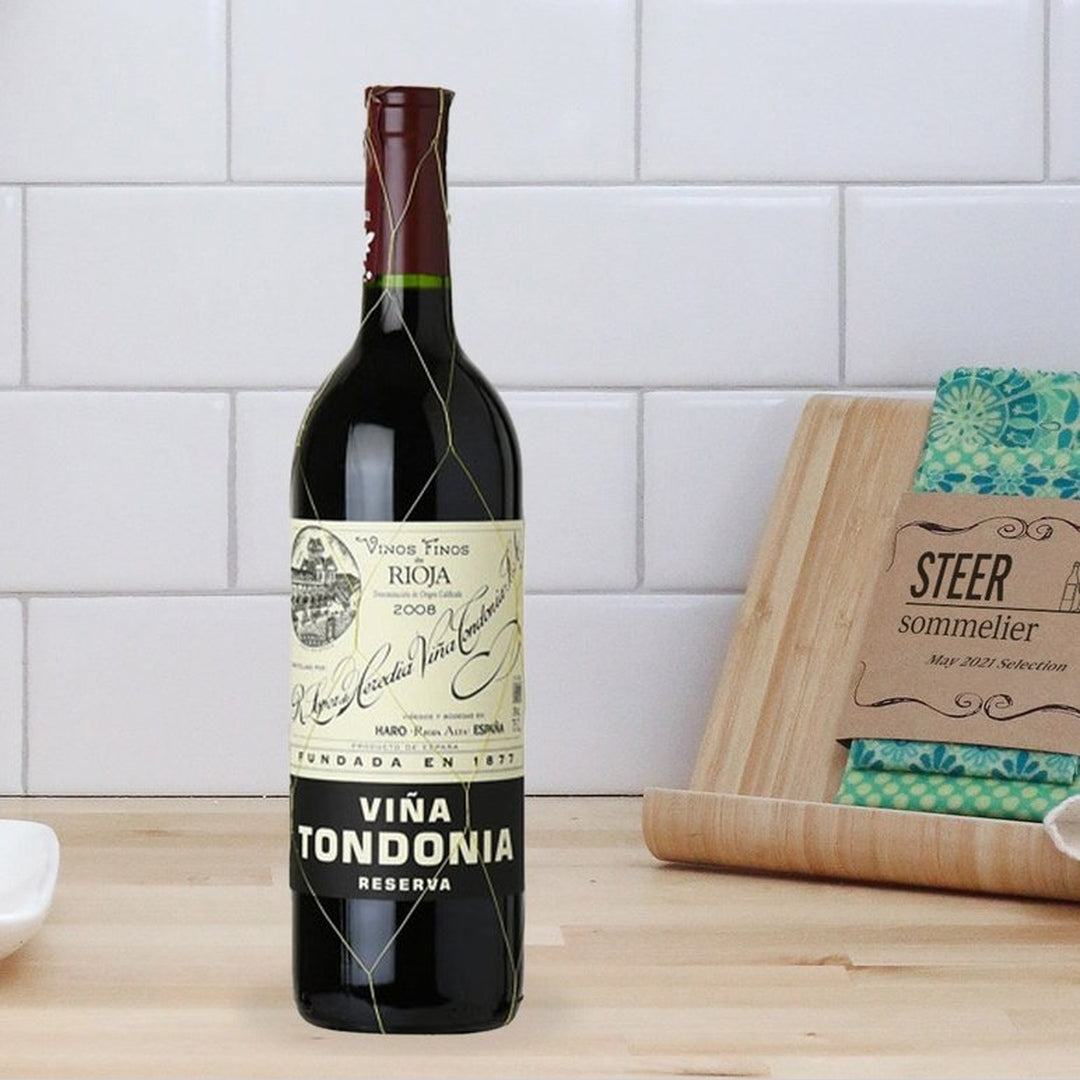 Front view of 2008 Vina Tondonia Reserva Rioja bottle showing label and gold wire netting on a countertop with a STEER card