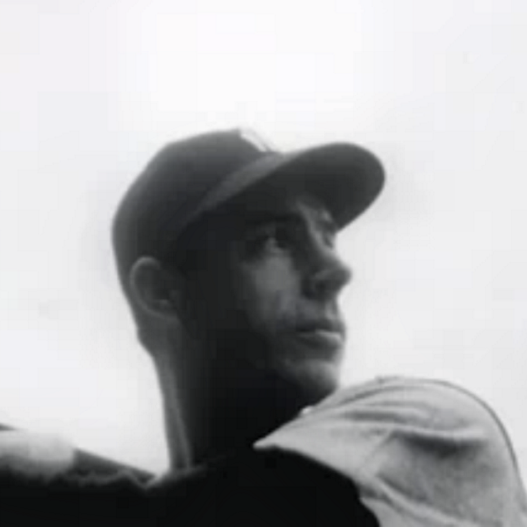 Black-and-white portrait of Joe DiMaggio wearing a cap, looking upward to the right