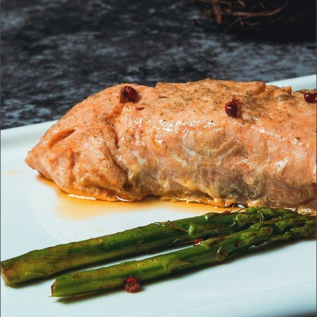 Garlic butter salmon fillet with asparagus on a white plate