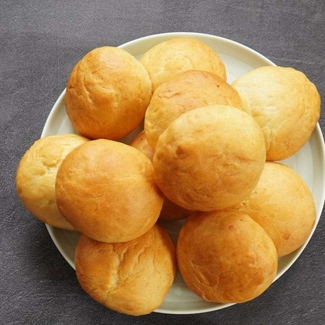 Warm buttered dinner rolls piled on a plate