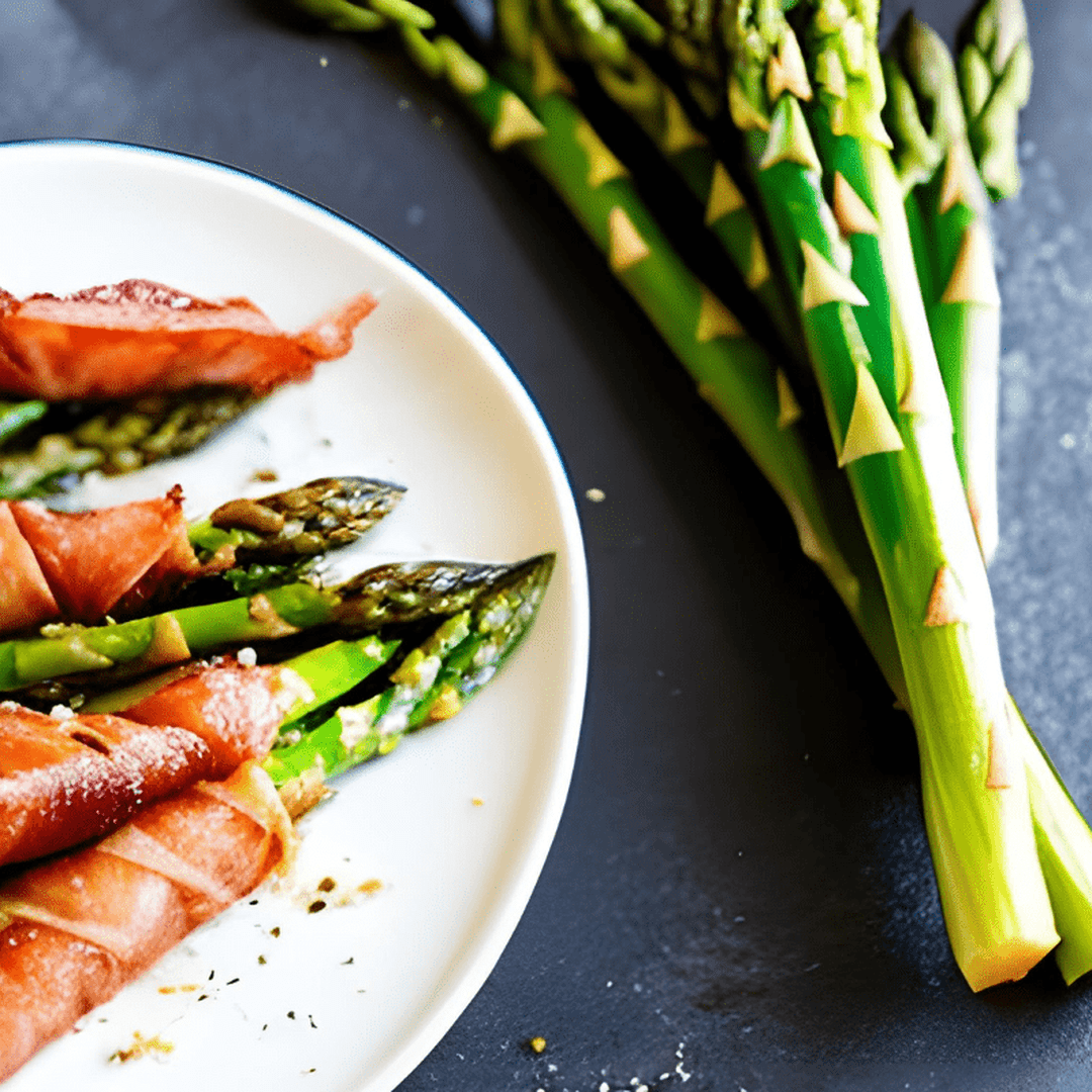 Prosciutto-wrapped asparagus spears on a white plate.
