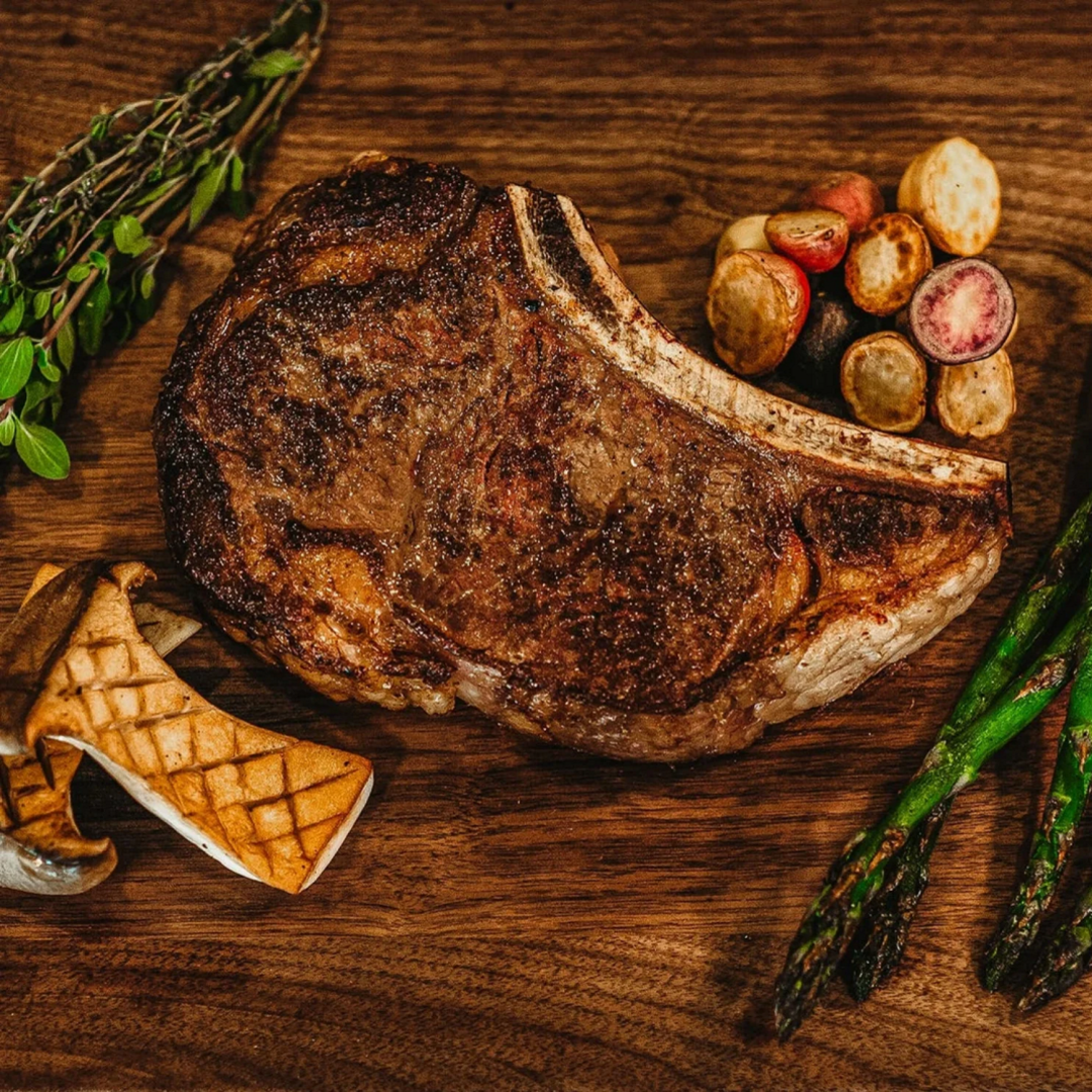 Cooked Ribeye with vegetables on a cutting board