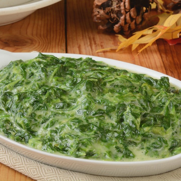 Creamed spinach with wilted greens in a white oval dish
