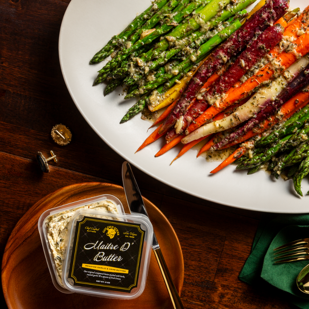 Asparagus and rainbow carrots with herb compound butter tub labeled Maitre D' Butter, Roasted Garlic & Herb Butter, NET WT 8 OZ