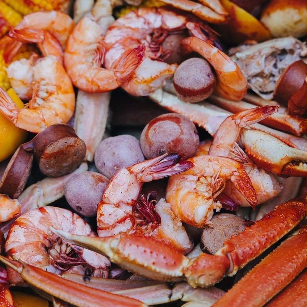 Shrimp and snow crab legs with red potatoes, sausage, and corn in a lemon-pepper seafood boil
