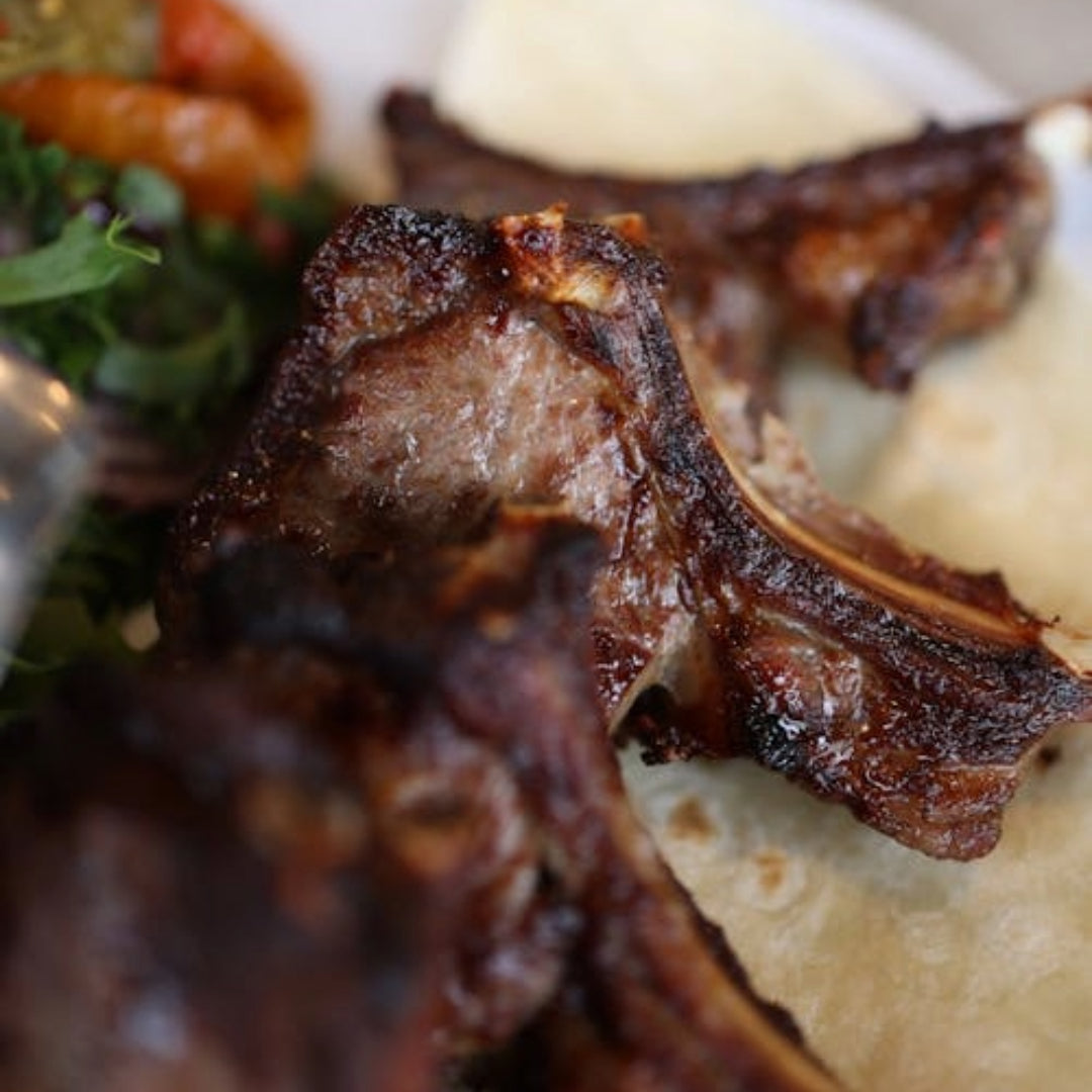 Roasted lamb chops served on flatbread with mashed potatoes and mixed greens