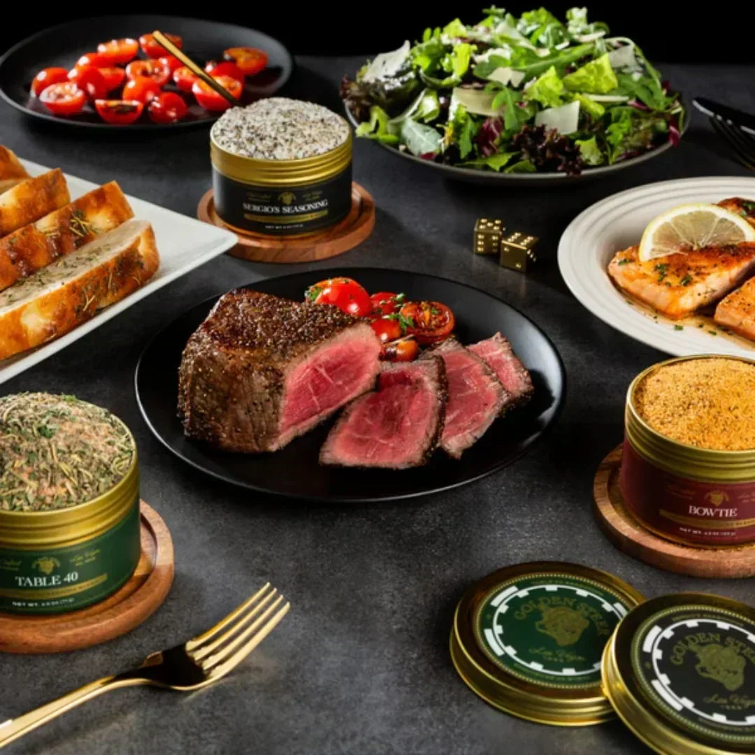 Front view of 308 Seasoning Set tins Sergio’s, Table 40, and Bowtie displayed with sliced medium-rare steak, salad, and sides