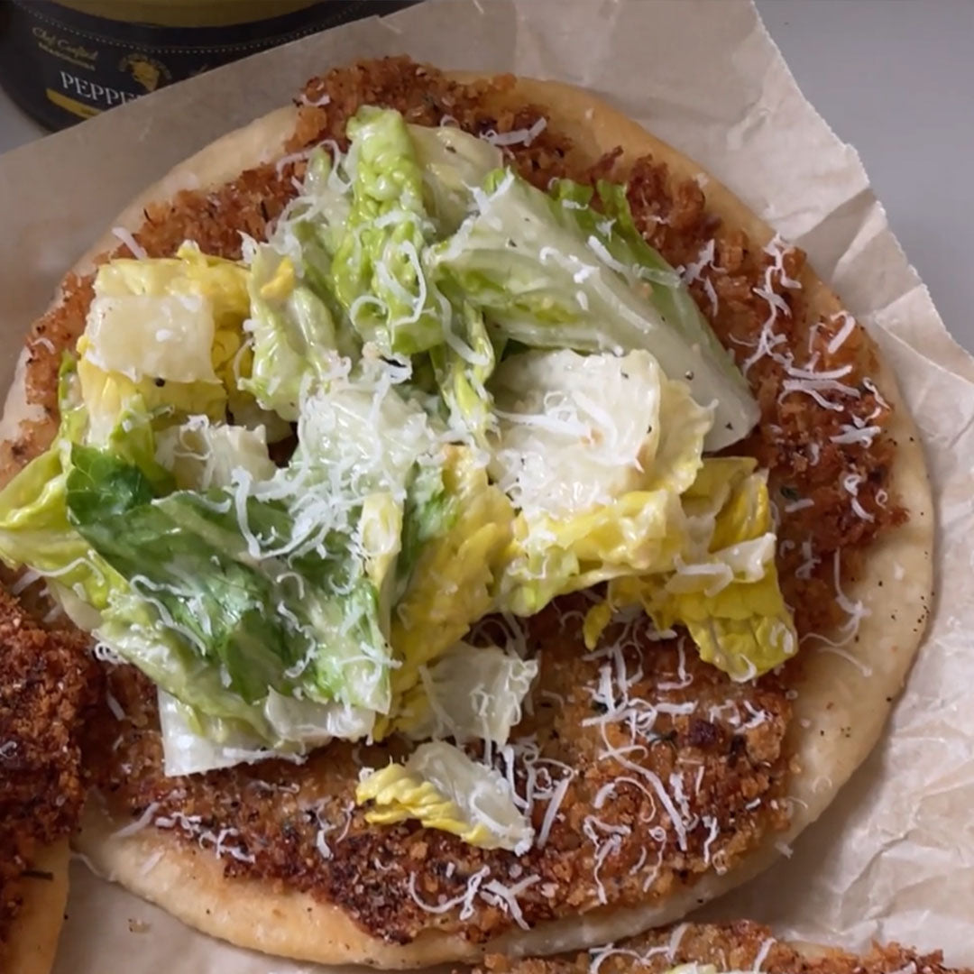 Crispy fried chicken on a round tortilla crust topped with romaine lettuce and shredded cheese