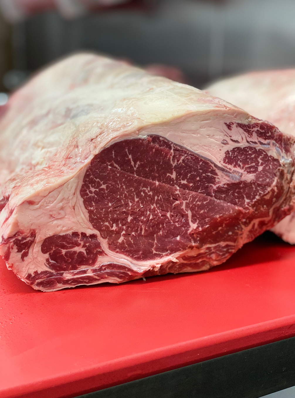 Raw ribeye on a red cutting board