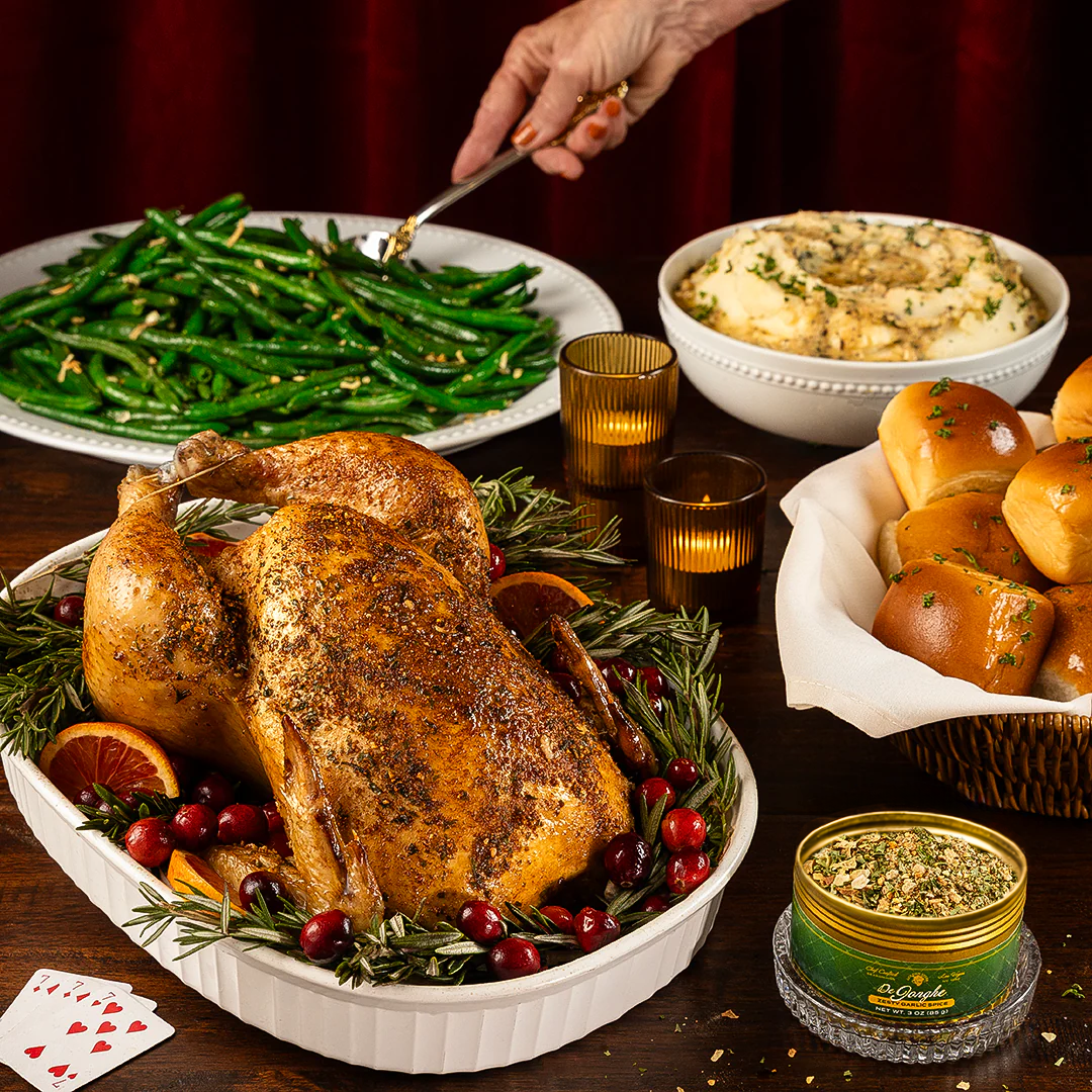 De Jonge Seasoning Roasted chickenwith green beans, mashed potatoes, and rolls on a table.