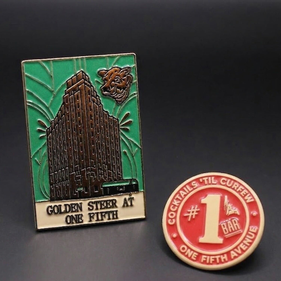 Two pins on a dark background, one with a building design reading One Fifth GOLDEN STEER AT ONE FIFTH, the other with a red circle and number one bar design reading COCKTAILS 'TIL CURFEW ONE FIFTH AVENUE.